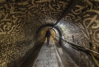 Anderlecht, Brussels, Belgium, 07 16 2019- Man walking in the industrial interiors of the sewer