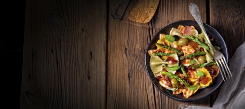 Pasta salad with green asparagus, olives and Parma ham