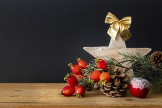 An image of a wooden Star with twig pine cone and rose hip background