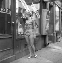 In the 1950s. A young woman dressed in underwear. She is wearing a bra and panties and is standing