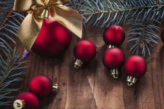 Christmas balls bow and fir tree branch on wood board