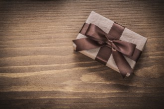 Packed gift on vintage wooden board top view holidays concept