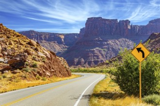 Wide asphalt highway among picturesque hills and rocks of bizarre shapes. The grandiose landscapes