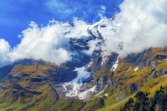 Snowy mountain peaks covered with clouds. Flowering alpine meadows and mountains of the Hohe Tauern