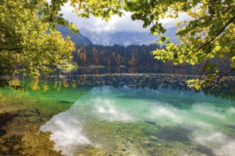 Picturesque lake Fusine in Northern Italy. The bright colors of the autumn forests are reflected in