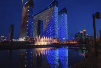 Orbi Beach Tower Batumi Aparts in blue hour. Reflection in pond of 2 skyscrapers (Orbi) and other