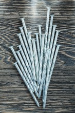 Heap of construction nails on wooden board