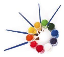 Gouache paints pots and brushes arranged into a circle