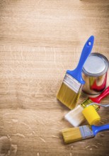 Organized copyspace three paint brushes roller can on wooden board construction concept