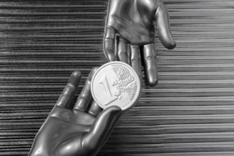 Silver euro coins in futuristic robot gray metallic hands bank metaphor