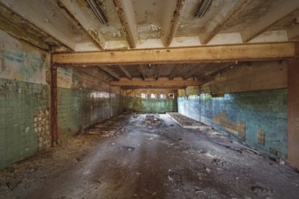 Abandoned and dilapidated interior of a school with green tiles and ceiling beams, HF6, Lost Place,
