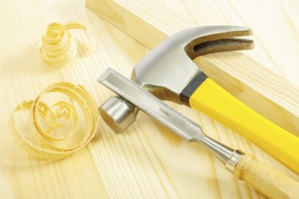 Claw hammer and chisel on wooden board