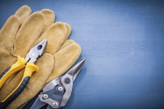 Pliers steel cutter leather protective gloves on wooden board