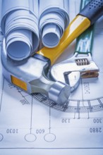 Blueprint rolls adjustable spanner and claw hammer construction concept