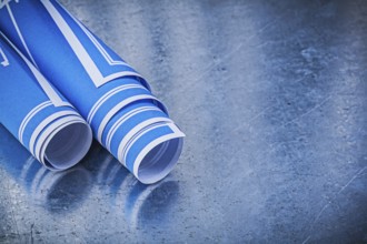 Pile of blue engineering drawings on metallic background construction concept