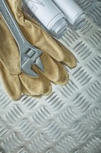 Blueprints adjustable spanner protective gloves on fluted metal sheet