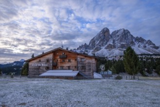 Utia de Borz hut in Passo Erbe after sunrise at the mountain Peitlerkofel, or Sass de Putia