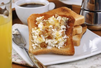 Crisp, fresh toast ricotta, honey and nuts for breakfast with orange juice and coffee