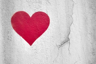 Red love heart hand drawn on grungy wall. Textured background trendy street style. Copy space