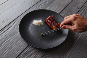 Grilled smoked eel with green apple and citrus chef hand preparing