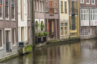 Row of traditional buildings along a quiet canal, Amsterdam, Netherlands