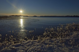 Sunny morning at seashore on a cold winter day with ice on the shoreline, Kallahdenniemi, Helsinki,