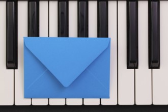 Funny arrangement envelope on the piano keybords - Flat lay image