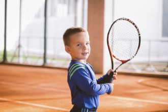 Child playing tennis on outdoor court. September 20, 2016, Ukraine, Kiev. Little tennis great