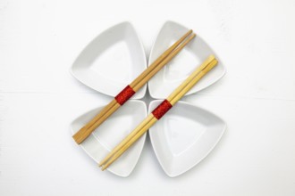 Ceramic bowls and bamboo chopsticks for sushi food with red and white decoration