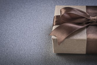 Boxed gift with brown knot on grey background copy space celebrations concept