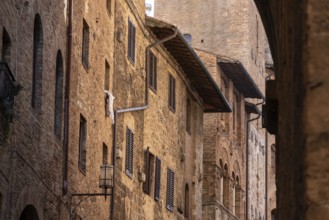 Facade of typical medieval residential houses in downtown San Gimignano, Italy, Europe