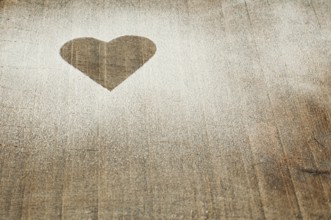 Heart pattern on an old wooden board. Heart made of sugar