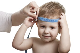 Measure tape in hand measuring child head isolated
