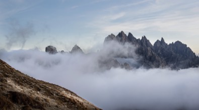 Mountain landscape with fog, at sunset Dolomites at Tre Cime hiking path area in South Tyrol in