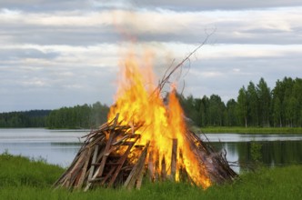 A big fire at a lake shore on Midsummer Day, Finland, Europe