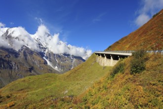 Snow-capped Alps in a beautiful autumn day. The platform supports and fences the highway