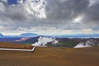 Krafla Lake neighborhood. Summer Iceland. Steam rises above the hot ground. Pipeline to transport