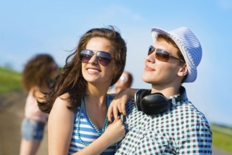 Young couple standing on the road, having fun with friends