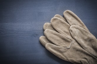 Two protective gloves on wooden board