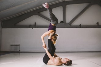 Yogi couple practice. Couple young sporty peoplepracticing acrobatic yoga lesson with partner, man