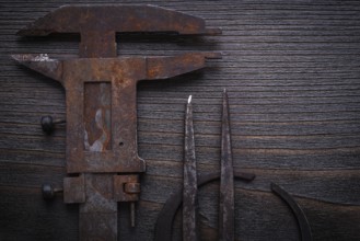 Top view of old-fashioned slide calipers on vintage wooden board
