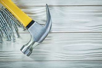 Claw hammer construction nails on wood board