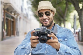 Handsome tourist checking photos in digital camera. High quality photo