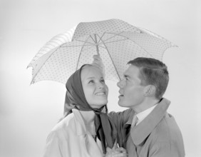 1960s couple. A happy smiling couple is standing under an umbrella. Sweden 1960 Conard ref 4254
