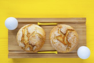 Golf breakfast - Two wheat bread and golf balls on wooden desk