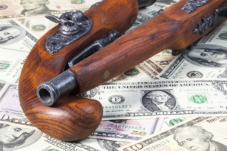 Old guns and dollar bills on the table
