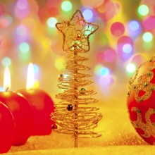 Christmas golden tree with baubles and candles in blur lights