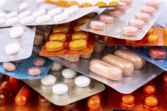 Different colorful capsules and pills in plastic packs - blisters stacked. Global pharmaceutical