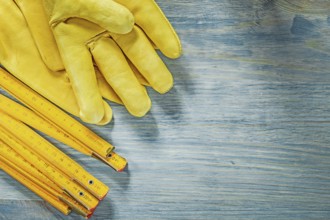 Wooden meter pair of leather safety gloves on wood board construction concept