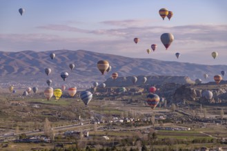 A picture of colorful hot air balloons flying over the landscape of Goreme Historical National Park